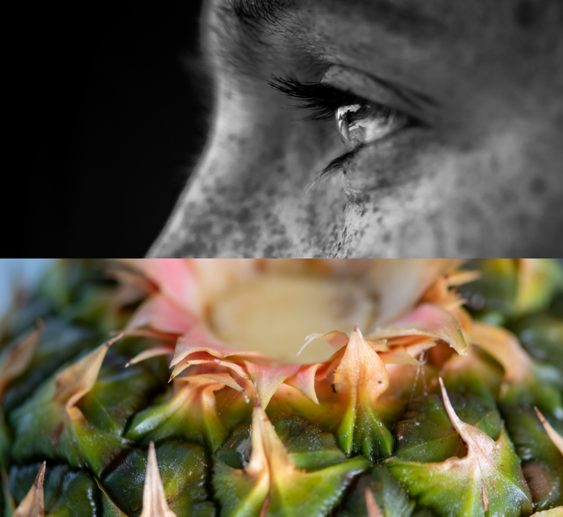 A pineapple and a young guy with freckles who looks to the left in close up for Yayot